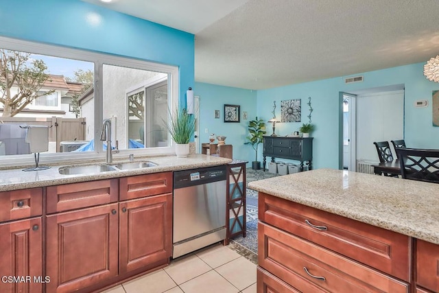 kitchen featuring sink, light tile patterned floors, stainless steel dishwasher, and light stone countertops