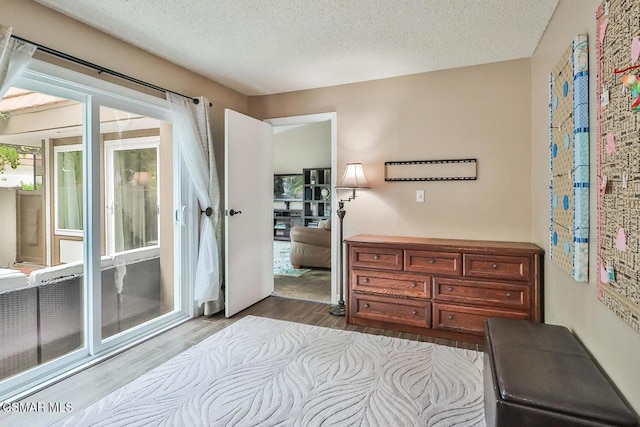 bedroom featuring light hardwood / wood-style flooring and a textured ceiling