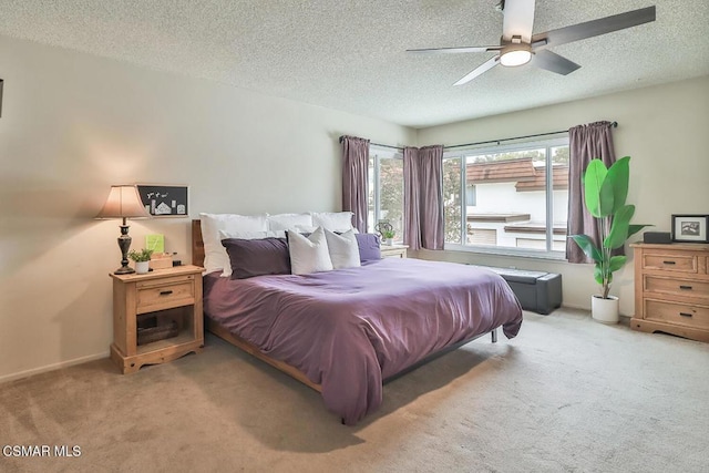 bedroom with ceiling fan, light carpet, and a textured ceiling