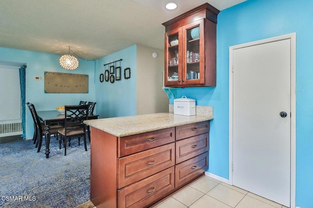 kitchen with light tile patterned flooring and light stone counters