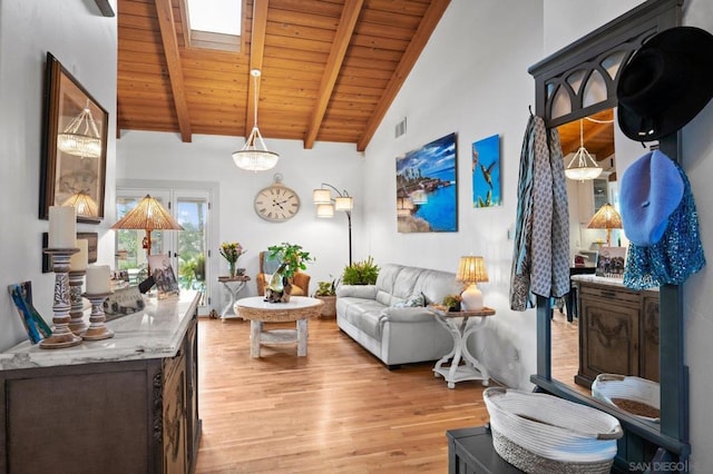 living room with a skylight, high vaulted ceiling, wooden ceiling, light wood-type flooring, and beam ceiling