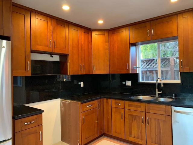 kitchen featuring white dishwasher, sink, decorative backsplash, and refrigerator