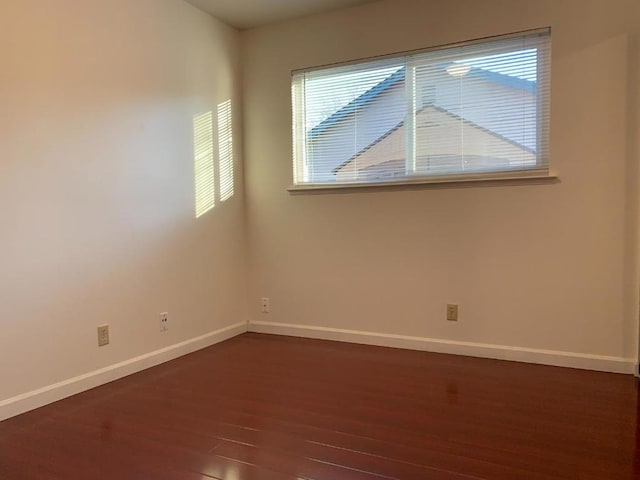 spare room with dark hardwood / wood-style flooring