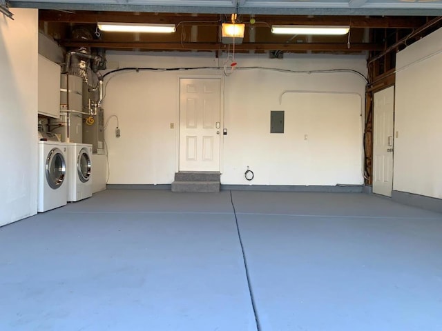 garage featuring electric panel, a garage door opener, and separate washer and dryer