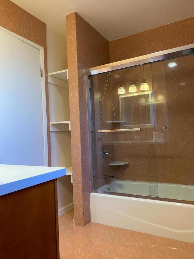 bathroom featuring vanity and combined bath / shower with glass door