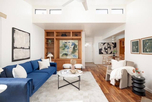 living room with hardwood / wood-style flooring and a towering ceiling