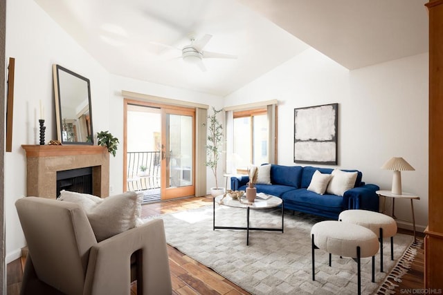 living room with lofted ceiling, ceiling fan, and light wood-type flooring