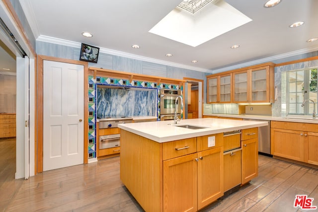 kitchen with sink, crown molding, an island with sink, and appliances with stainless steel finishes