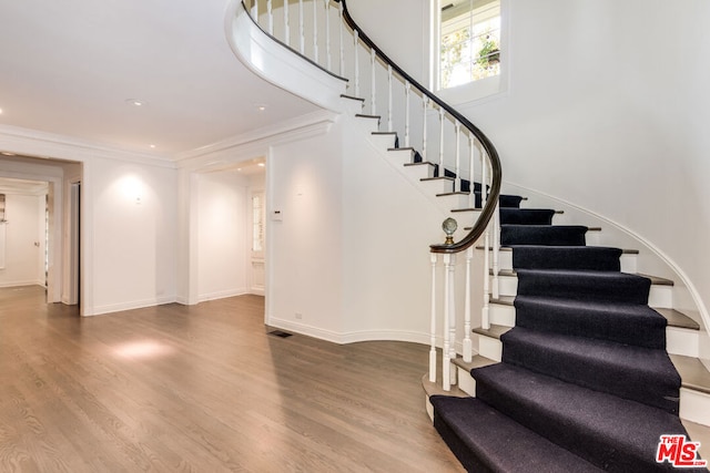 stairway featuring hardwood / wood-style flooring and ornamental molding