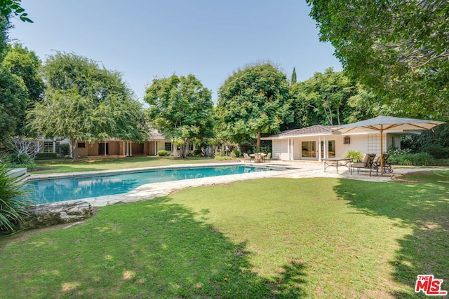 view of swimming pool with a patio and a lawn