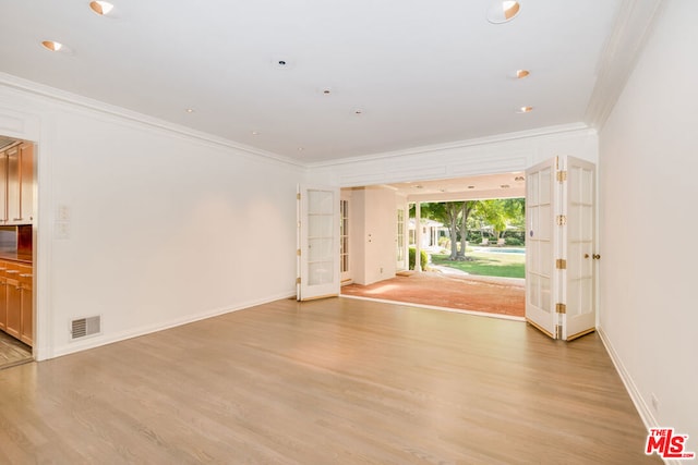 unfurnished room featuring ornamental molding and light hardwood / wood-style floors