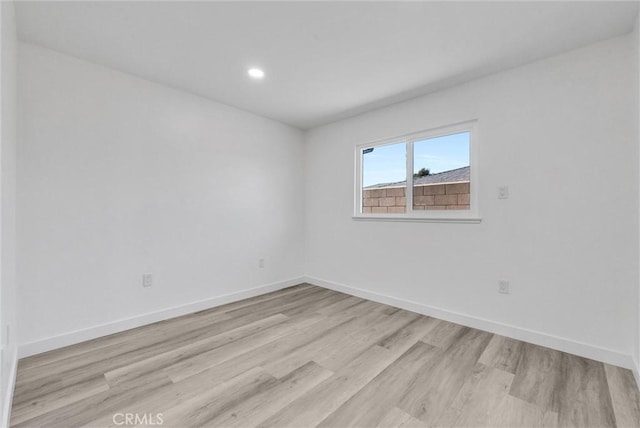 empty room with light hardwood / wood-style flooring