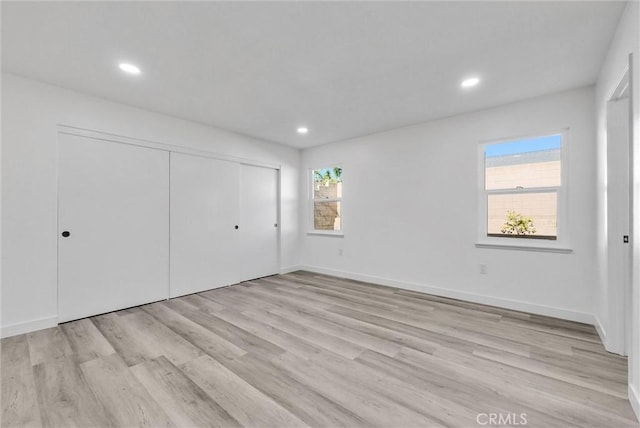 unfurnished bedroom featuring light hardwood / wood-style flooring and a closet