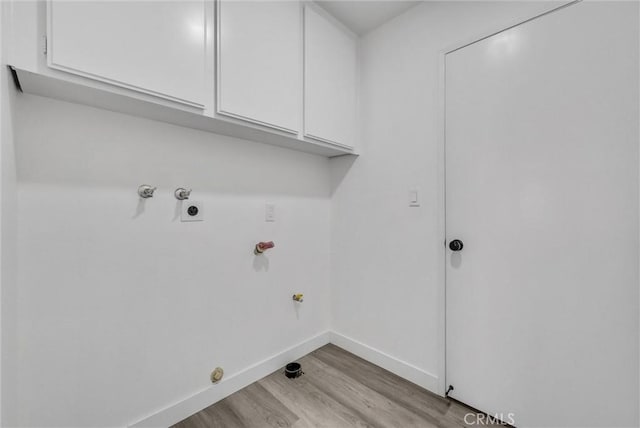 clothes washing area with cabinets, washer hookup, light hardwood / wood-style flooring, and hookup for a gas dryer