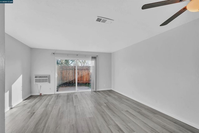 unfurnished living room featuring a wall mounted air conditioner, light hardwood / wood-style floors, and ceiling fan