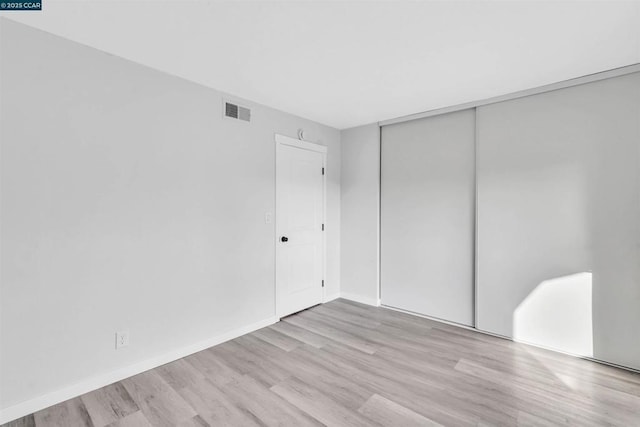 unfurnished bedroom featuring a closet and light hardwood / wood-style flooring