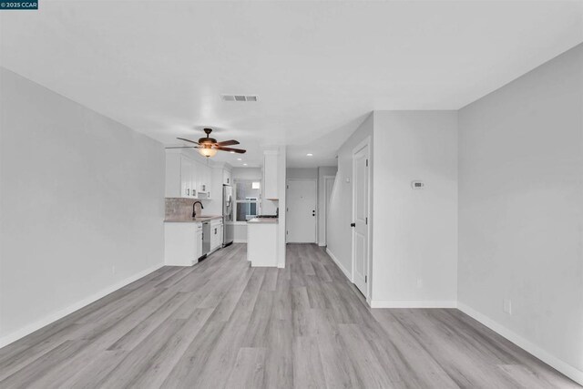 unfurnished living room featuring ceiling fan, sink, and light hardwood / wood-style floors