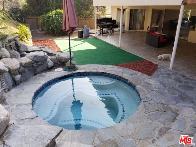 view of swimming pool featuring a patio area and an in ground hot tub