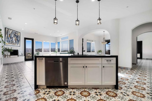 kitchen featuring a kitchen island with sink, hanging light fixtures, white cabinets, and dishwasher