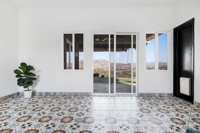 empty room featuring a mountain view and a wealth of natural light