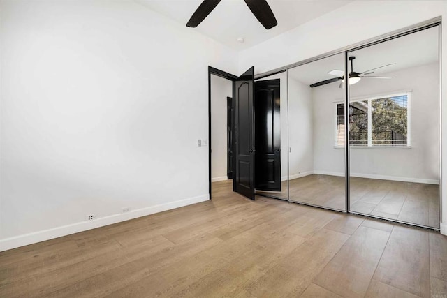 unfurnished bedroom with light hardwood / wood-style flooring, a closet, and ceiling fan