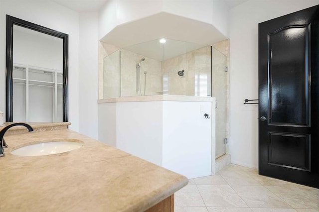 bathroom with an enclosed shower, vanity, and tile patterned floors