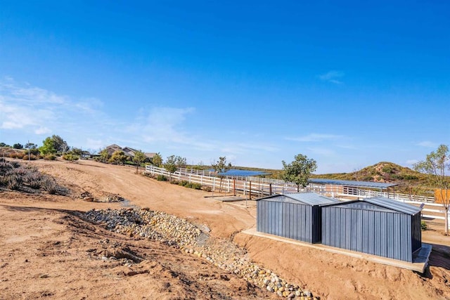 view of yard featuring an outbuilding and a rural view