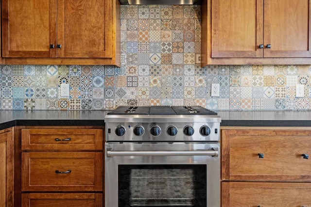 kitchen featuring tasteful backsplash, stainless steel stove, and wall chimney range hood