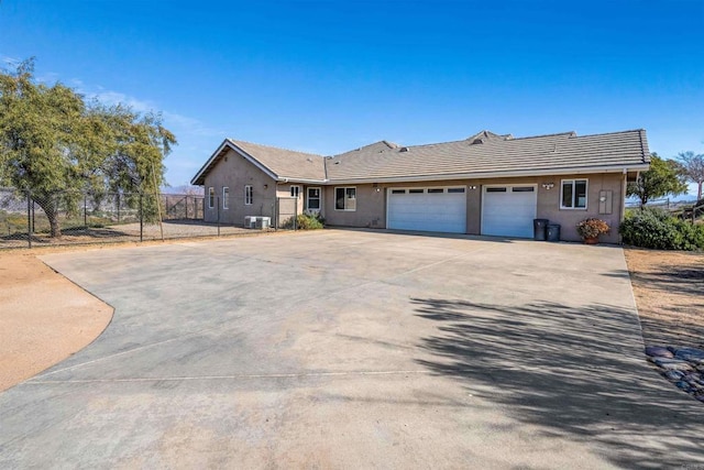 ranch-style house featuring cooling unit and a garage