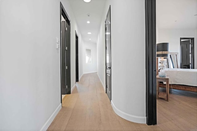 hallway with light hardwood / wood-style floors