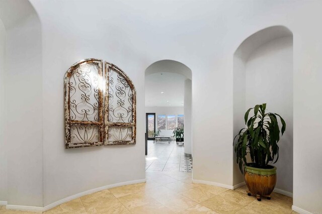 24916 Bareta Star Ranch Rd, Ramona, CA 92065 - hall with arched walkways, baseboards, and light tile patterned floors