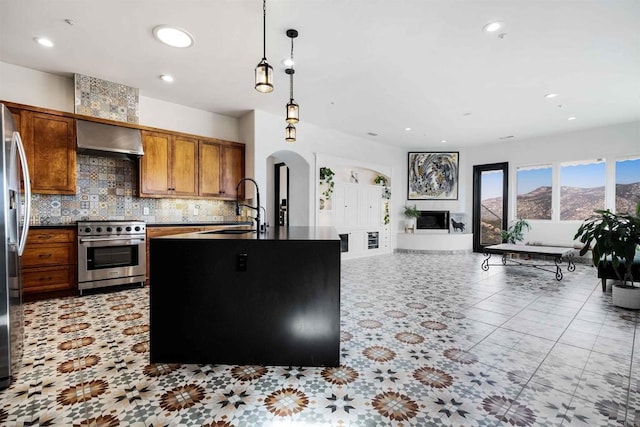 24916 Bareta Star Ranch Rd, Ramona, CA 92065 - kitchen featuring high end range, exhaust hood, a sink, arched walkways, and tasteful backsplash