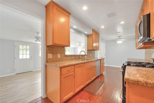 kitchen with visible vents, decorative backsplash, light wood-style flooring, appliances with stainless steel finishes, and a sink