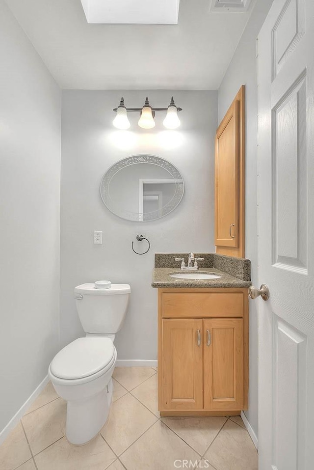 half bath with vanity, visible vents, baseboards, tile patterned floors, and toilet