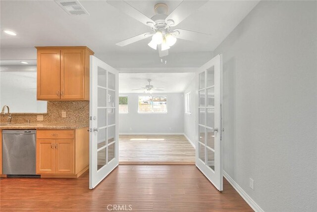 kitchen with visible vents, decorative backsplash, french doors, wood finished floors, and stainless steel dishwasher