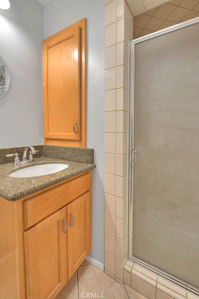 full bathroom featuring tile patterned flooring, vanity, and a stall shower