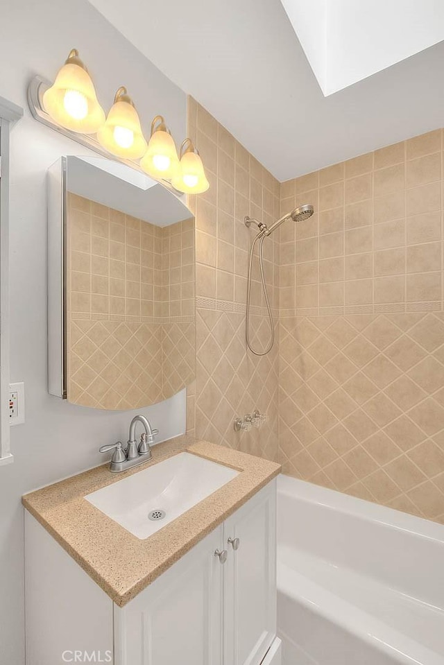 bathroom featuring shower / tub combination, a skylight, and vanity