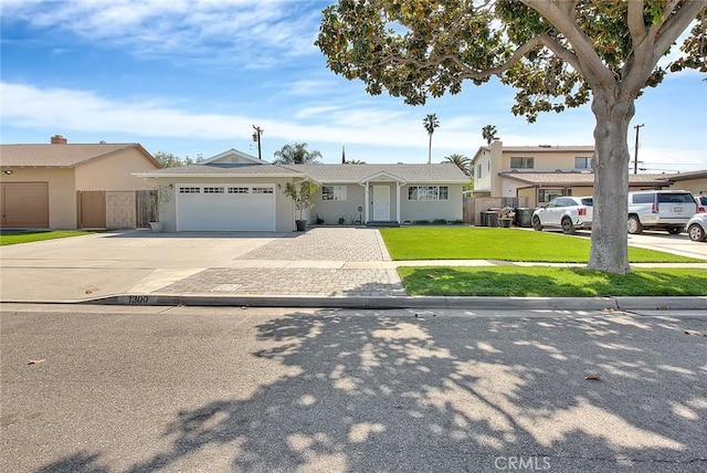 view of front of home with an attached garage, driveway, a front yard, and fence