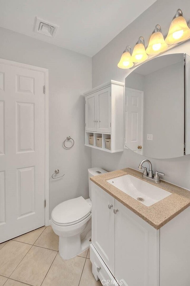 half bathroom with tile patterned floors, visible vents, toilet, and vanity