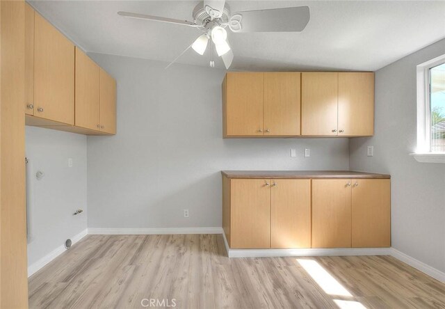 kitchen featuring baseboards, a ceiling fan, and light wood finished floors