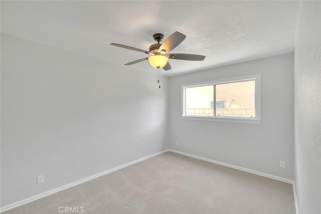 unfurnished room featuring a ceiling fan, baseboards, a textured ceiling, and carpet flooring