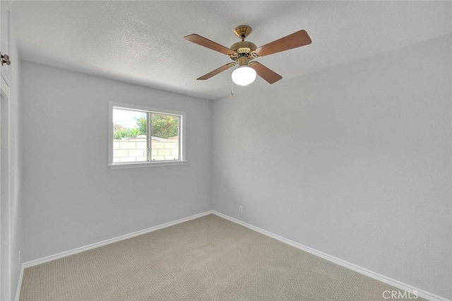 carpeted empty room featuring ceiling fan, baseboards, and a textured ceiling