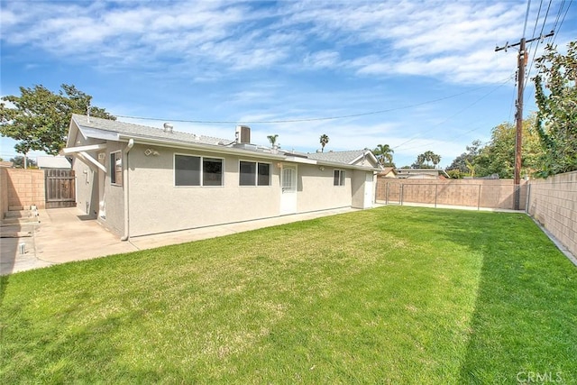 rear view of property featuring a fenced backyard, stucco siding, a patio, and a yard