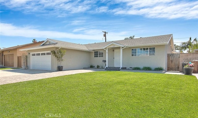 ranch-style home featuring a front lawn, decorative driveway, a garage, and stucco siding