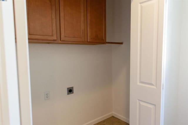 washroom featuring electric dryer hookup and cabinets