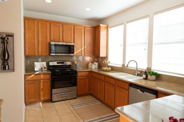 kitchen with tasteful backsplash, sink, light tile patterned floors, and stainless steel appliances