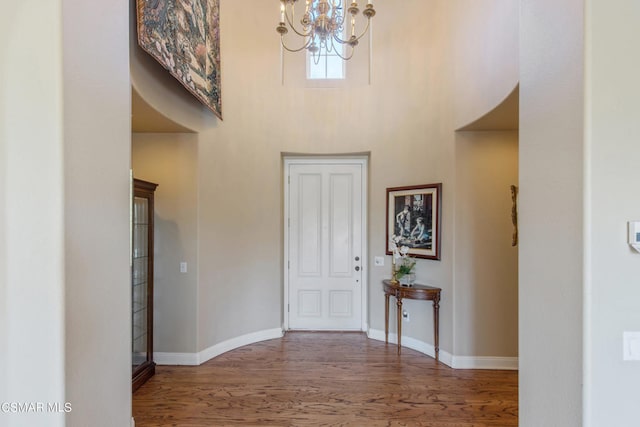 entrance foyer with a notable chandelier, dark hardwood / wood-style flooring, and a high ceiling