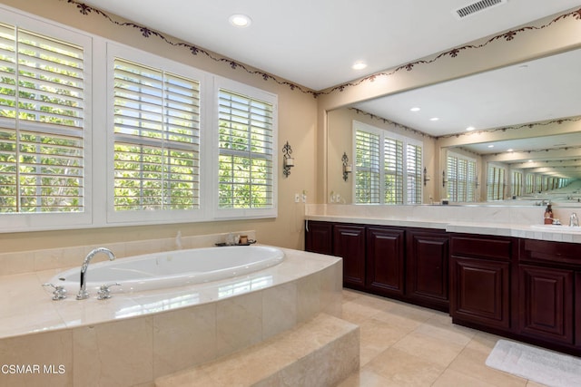 bathroom featuring vanity, tile patterned floors, and tiled bath