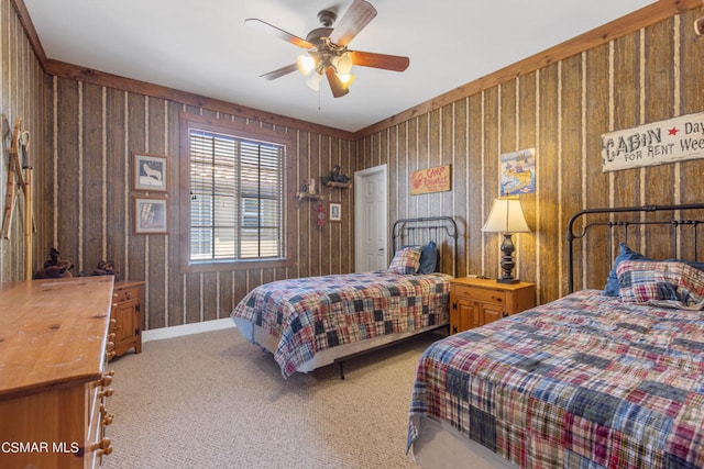 bedroom with ceiling fan, light colored carpet, and wood walls