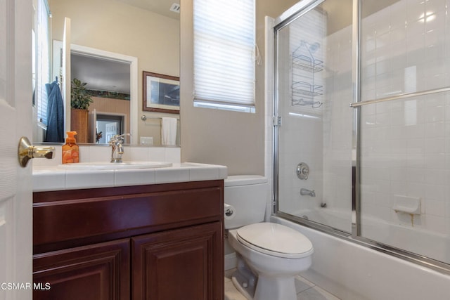 full bathroom with tile patterned floors, vanity, toilet, and combined bath / shower with glass door